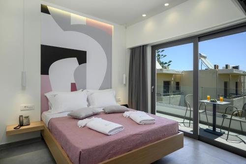 普拉塔尼亚斯Athina Suites Platanias的一间带大床的卧室和一个阳台