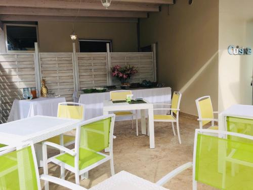 加利波利Villa dei Ginepri的用餐室配有白色的桌子和黄色的椅子