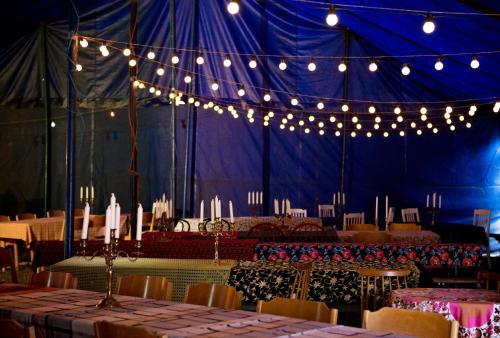 InkooCirkus Hostel Holken的蓝色帐篷配有桌椅和灯