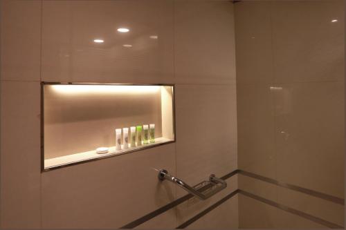 西波列蒂Hotel y Casino Del Río - Cipolletti的一间带镜子和淋浴的浴室