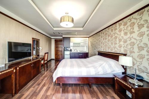 巨济巨济绿洲酒店的一间卧室配有一张床和一台平面电视