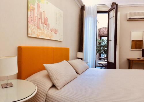 卡塔尼亚桑久利安诺114住宿加早餐酒店的卧室配有白色的床和桌子