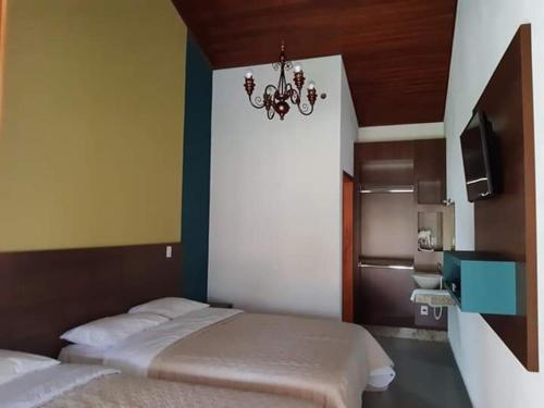 Santo Antônio do AmparoRECANTO MARIANE的一间卧室配有两张床和吊灯。