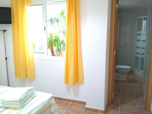 内尔哈百夫长公寓 的浴室设有床和黄色窗帘的窗户