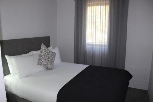 曼哲拉曼杜拉中庭酒店的卧室配有白色的床和窗户。