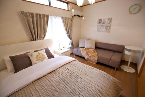 东京The 3rd Residential Suite SHIROKANE的一间卧室配有一张大床和一张沙发