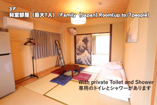 广岛RED HELMET House & Sports Bar Hiroshima的小房间设有一张床和一台冰箱