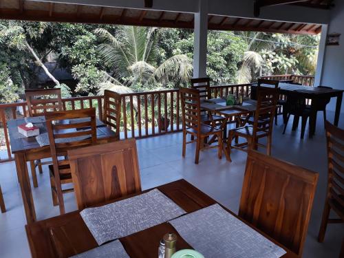龙目岛库塔西拉民宿的一间带木桌和椅子的餐厅以及一个阳台