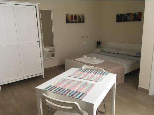 兰佩杜萨Camere a Sud - Lampedusa的客房设有一张床和一张白色的桌子及椅子。