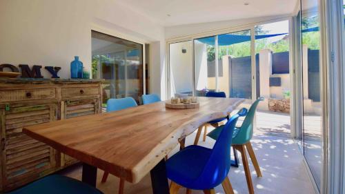 圣马克西姆Charmante maison centre-ville Sainte-Maxime, plages à 2 pas的一间带木桌和蓝色椅子的用餐室