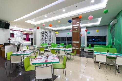 茂物茂物帕德加加兰法维酒店的餐厅设有绿色桌椅和气球