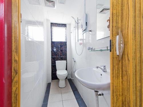 雪邦Super OYO 414 Adiff Palace Hotel的白色的浴室设有卫生间和水槽。