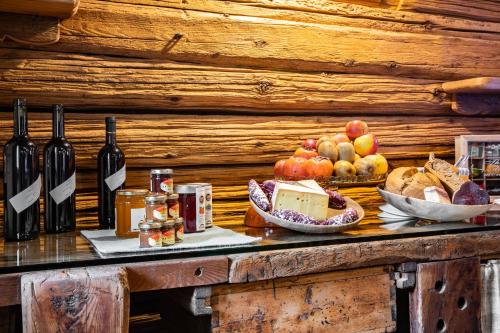 奥斯塔Chambres d'hôtes La Moraine Enchantée的一张桌子,上面放有葡萄酒、水果和面包