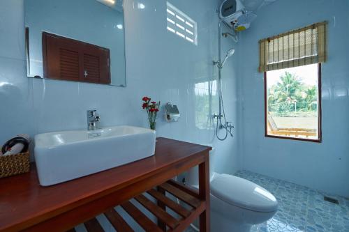 Nguyệt HạngTra Vinh Lodge的一间带水槽和卫生间的浴室以及窗户。