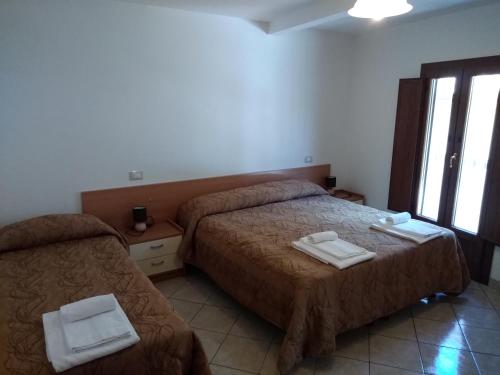 阿塞尔吉Il Narciso appartamenti的酒店客房设有两张床和窗户。