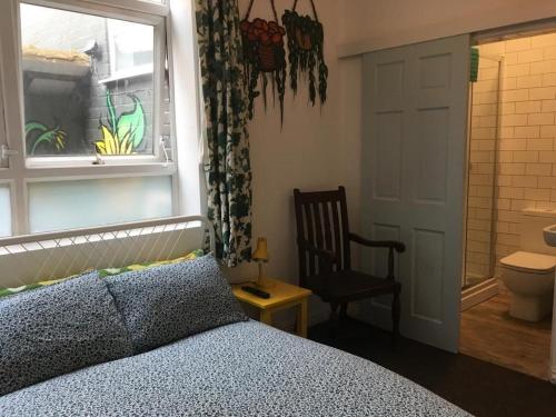 诺丁汉混合冰屋旅舍的一间卧室设有一张床、一个窗口和一把椅子