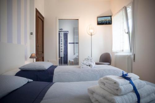 Piombino DeseLa Casa di Amedeo的两张位于酒店客房的床,配有毛巾