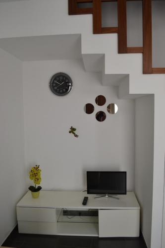 Barão de São JoãoCasa Madalena的一间设有一张桌子的房间,墙上挂着一个时钟