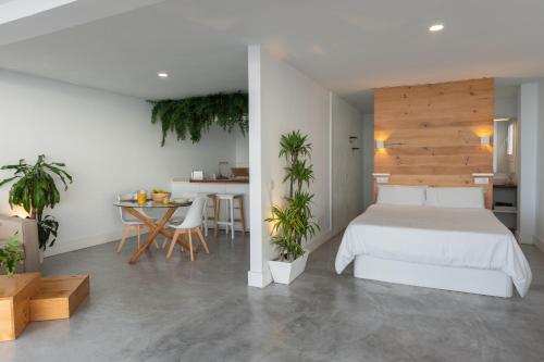 巴哈马尔Waves Nest - Bajamar的卧室配有白色的床和植物桌子