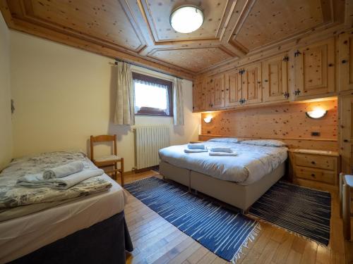 利维尼奥Residence Livigno MyHolidayLivigno的一间卧室设有两张床和木制天花板