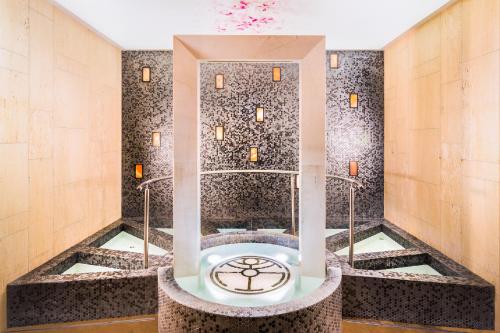 帕维尔巴尼亚Hotel Sevtopolis Medical & SPA的一间带一个浴缸及一个钟表的浴室