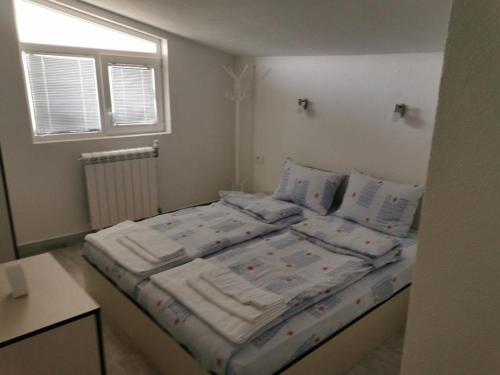 贝罗沃Diva Kompani Rooms的一间卧室配有带3个枕头的床和窗户。