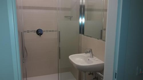 梅拉诺拉克斯酒店的一间带水槽和玻璃淋浴的浴室