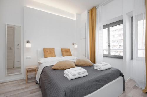 罗马德古斯蒂伯斯酒店的白色卧室配有带2条毛巾的床