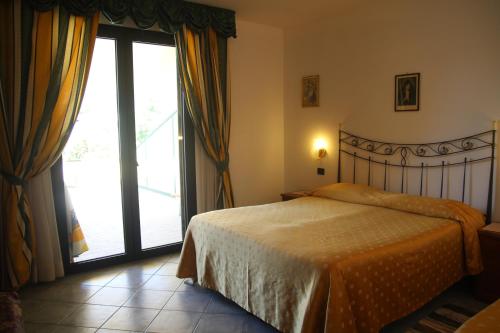 坎普码头Hotel La Barcarola的一间卧室设有一张床和一个大窗户