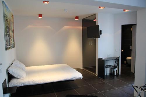 卢森堡歌睿酒店的一间卧室配有一张床、一张书桌和一台电视