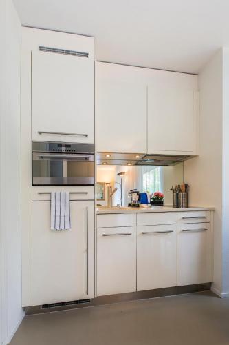 苏黎世Nest - Neptun Studio at Seefeld的厨房配有白色橱柜和炉灶烤箱。