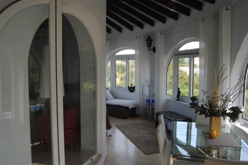 德尼亚Villa Bozena的客厅设有拱形窗户和玻璃桌