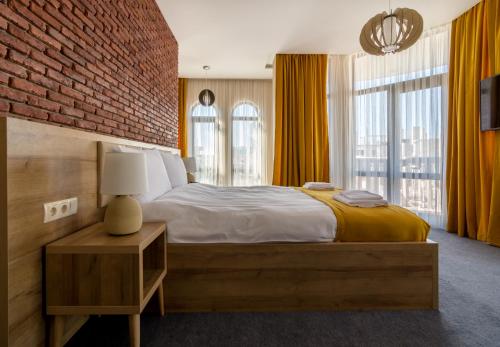 巴统Hotel London的一间卧室设有一张大床和砖墙
