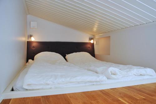 斯特伦斯塔德Fornminnesvägen的一张带白色床单和枕头的床