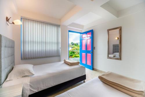 萨兰托Hotel El Jardin的一间卧室设有两张床和窗户。