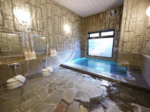 岛田岛田站前路线酒店的带浴缸的浴室以及电视。