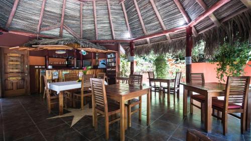 萨玛拉绿色小壁虎酒店的用餐室配有木桌和椅子