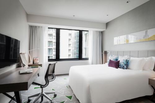 布里斯班布里斯班辉盛凯贝丽酒店式服务公寓的酒店客房设有一张白色大床和一张书桌