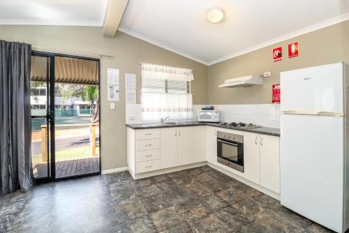 巴瑟尔顿Discovery Parks - Busselton的厨房配有白色橱柜和冰箱。