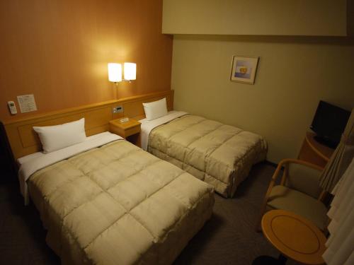 酒田市酒田罗特茵酒店的酒店客房,配有两张床和椅子