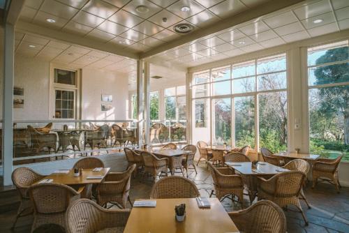 亚拉格林Chateau Yering的餐厅设有桌椅和窗户。