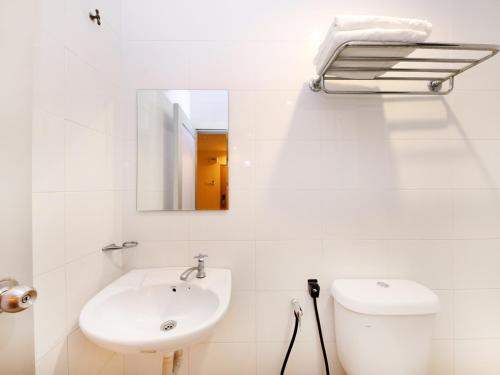 劳勿Super OYO 635 Seven Days Hotel的白色的浴室设有水槽和镜子