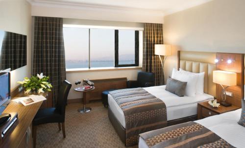 伊兹密尔伊兹密尔瑞享酒店的配有一张床和一张书桌的酒店客房