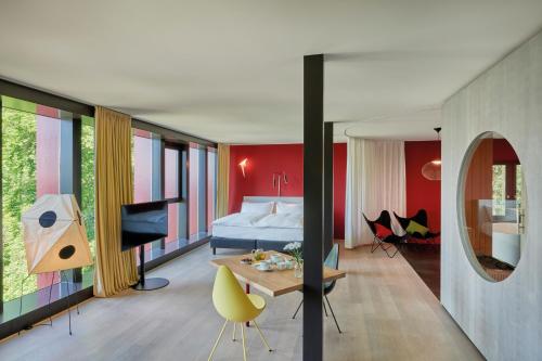 苏黎世Sorell Hotel Rigiblick - Studios & Spa Suites的一间卧室配有一张床,另一间卧室配有桌子