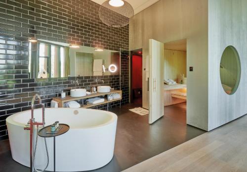 苏黎世Sorell Hotel Rigiblick - Studios & Spa Suites的带浴缸和盥洗盆的大浴室