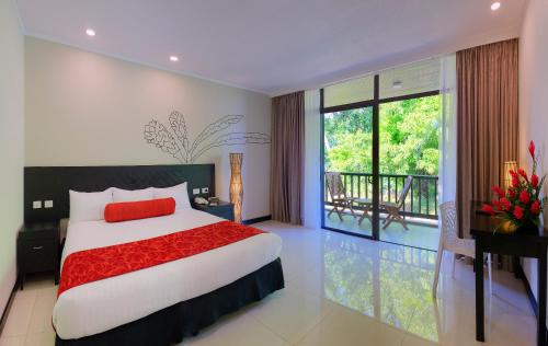 南迪塔努阿国际大酒店的一间带大床的卧室和一个阳台