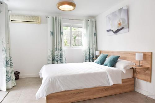 塔马兰塔马林住宿加早餐酒店的一间卧室配有带白色床单和蓝色枕头的床。