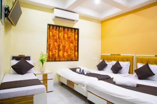 孟买AL Shifa Residency的一间设有两张床的客房,墙上挂着一幅画