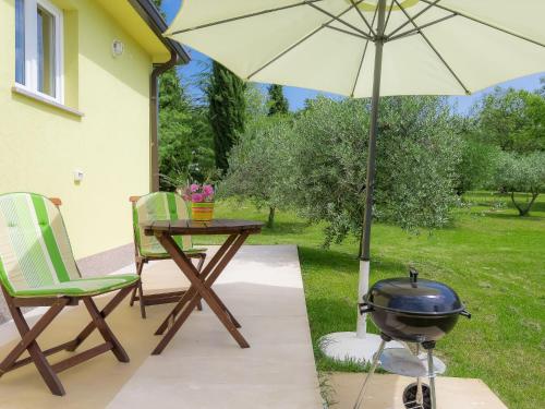 VinežHoliday Home Lucija by Interhome的庭院设有烧烤架和带烧烤设施的桌子。