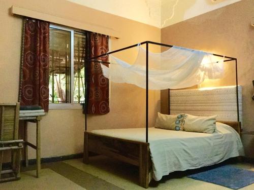 巴马科Auberge Djamilla的一间卧室配有一张带天蓬的床